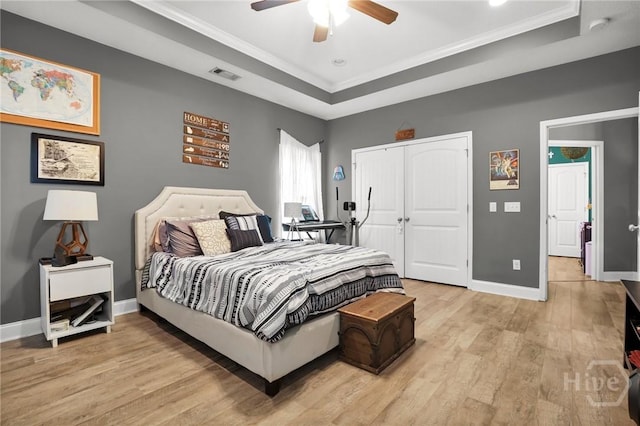 1416 Hillridge Dr, Darien, GA 31305 - bedroom featuring a raised ceiling, light wood-style flooring, ornamental molding, a closet, and ceiling fan