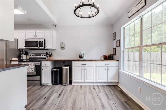 26 Dianne Mackenzie Way, Savannah, GA 31419 - kitchen with stainless steel appliances, a chandelier, white cabinetry, light wood-type flooring, and dark countertops