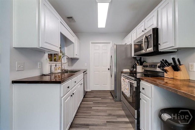 26 Dianne Mackenzie Way, Savannah, GA 31419 - kitchen featuring stainless steel appliances, white cabinets, wood finished floors, and butcher block counters