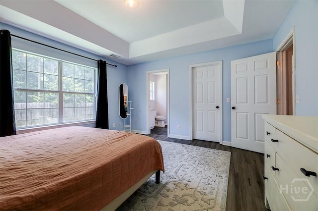 26 Dianne Mackenzie Way, Savannah, GA 31419 - bedroom with connected bathroom, a raised ceiling, and dark wood-style floors