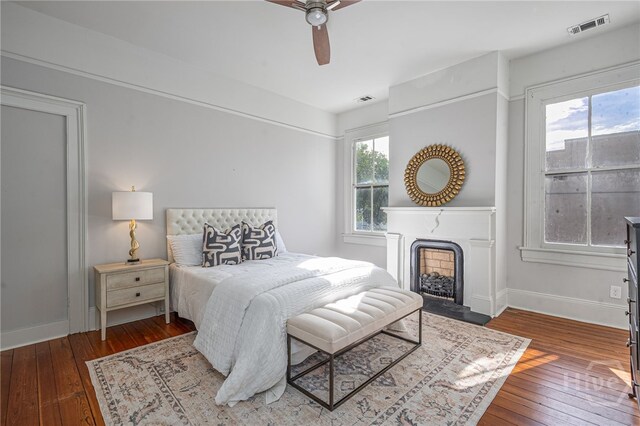 121 W Bolton St, Savannah, GA 31401 - bedroom with wood-type flooring, a fireplace, and a ceiling fan