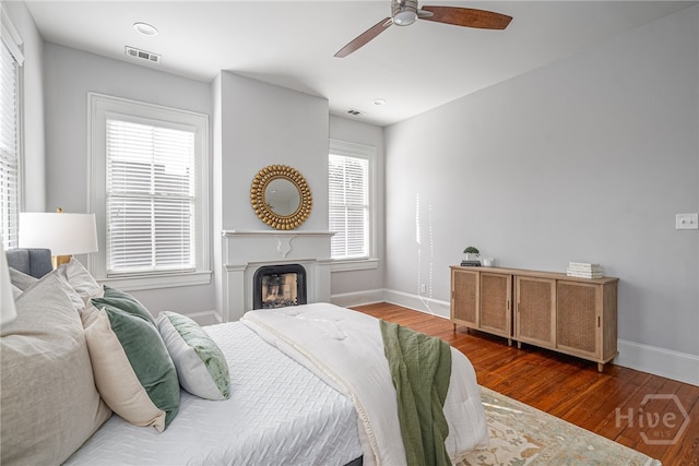 121 W Bolton St, Savannah, GA 31401 - bedroom with wood finished floors, a ceiling fan, and a fireplace