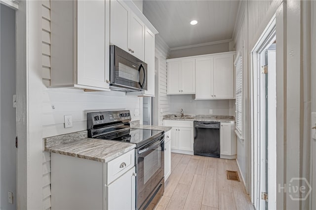121 W Bolton St, Savannah, GA 31401 - kitchen featuring black appliances, recessed lighting, light wood-type flooring, white cabinetry, and light stone countertops