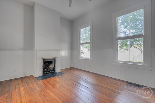 121 W Bolton St, Savannah, GA 31401 - unfurnished living room featuring a fireplace with flush hearth, wainscoting, hardwood / wood-style floors, and ceiling fan