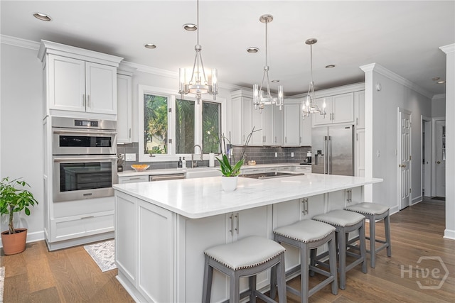 1 Broomsedge Ln, Savannah, GA 31411 - kitchen featuring stainless steel appliances, decorative backsplash, a kitchen island, a chandelier, and crown molding