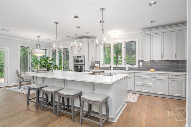 1 Broomsedge Ln, Savannah, GA 31411 - kitchen featuring a chandelier, double oven, a kitchen island, decorative backsplash, and light countertops