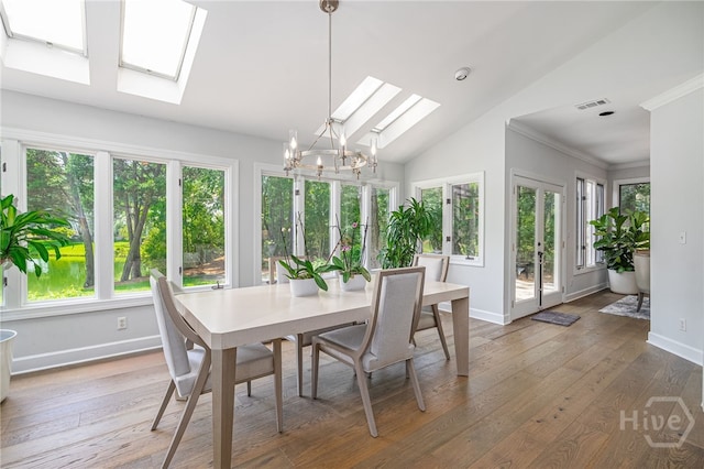1 Broomsedge Ln, Savannah, GA 31411 - dining area featuring a skylight, plenty of natural light, a chandelier, lofted ceiling, and light wood-style flooring