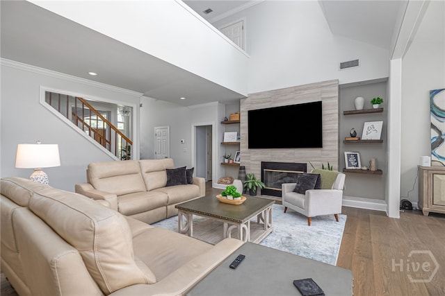 1 Broomsedge Ln, Savannah, GA 31411 - living area with ornamental molding, wood finished floors, stairway, a high end fireplace, and built in shelves