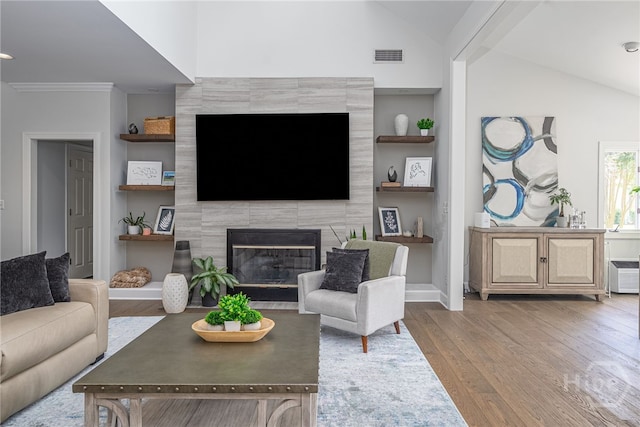1 Broomsedge Ln, Savannah, GA 31411 - living area with wood finished floors, lofted ceiling, a tiled fireplace, and built in features