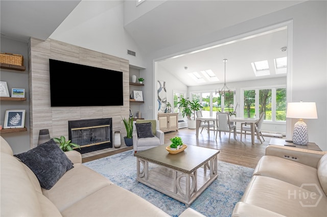 1 Broomsedge Ln, Savannah, GA 31411 - living room with lofted ceiling, wood finished floors, a skylight, a tiled fireplace, and built in features