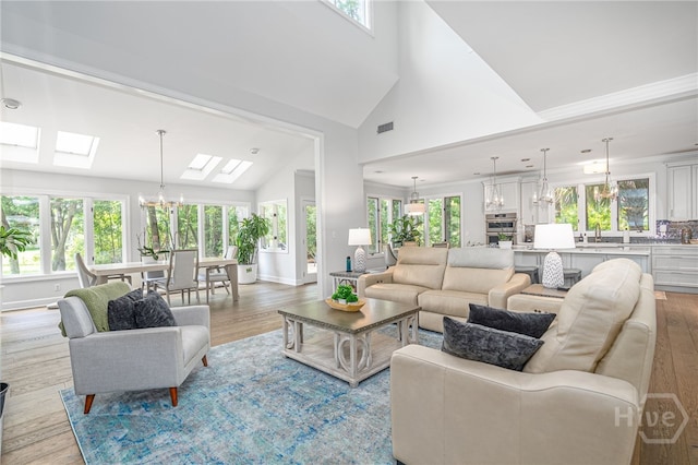 1 Broomsedge Ln, Savannah, GA 31411 - living area featuring a skylight, light wood-style flooring, a chandelier, and high vaulted ceiling