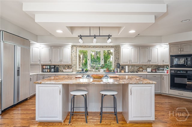 32 Hasleiters Retreat Retreat, Savannah, GA 31411 - kitchen featuring black appliances, a kitchen island, a kitchen breakfast bar, tasteful backsplash, and recessed lighting