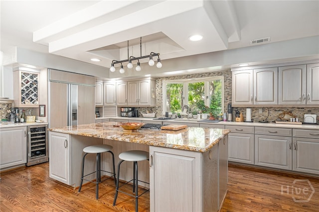 32 Hasleiters Retreat Retreat, Savannah, GA 31411 - kitchen with wine cooler, a tray ceiling, a kitchen island, decorative backsplash, and paneled fridge