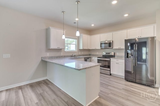 1057 Waybridge Way, Richmond Hill, GA 31324 - kitchen with appliances with stainless steel finishes, a peninsula, white cabinets, light wood finished floors, and recessed lighting