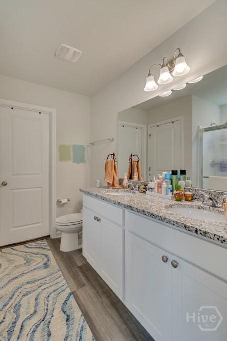 1057 Waybridge Way, Richmond Hill, GA 31324 - full bathroom with double vanity, a stall shower, and wood finished floors