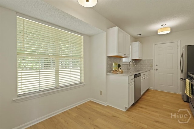 127 Laurel Green Ct, Savannah, GA 31419 - kitchen with light wood finished floors, white cabinetry, stainless steel appliances, tasteful backsplash, and a textured ceiling