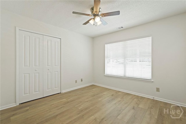 127 Laurel Green Ct, Savannah, GA 31419 - unfurnished bedroom featuring light wood-style floors, a closet, a textured ceiling, and a ceiling fan