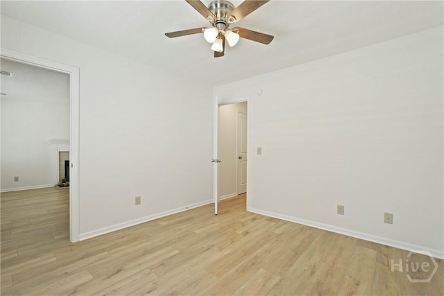127 Laurel Green Ct, Savannah, GA 31419 - empty room featuring light wood-style floors, ceiling fan, and a fireplace with raised hearth