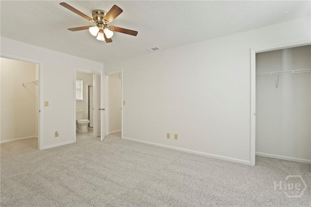 127 Laurel Green Ct, Savannah, GA 31419 - unfurnished bedroom featuring a closet, a walk in closet, light carpet, ensuite bath, and a textured ceiling