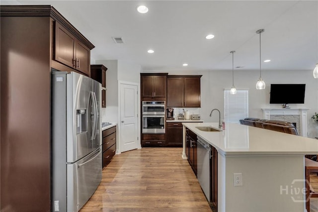 115 Merribee Ln, Pooler, GA 31322 - kitchen featuring appliances with stainless steel finishes, light wood-style floors, open floor plan, light countertops, and dark brown cabinetry