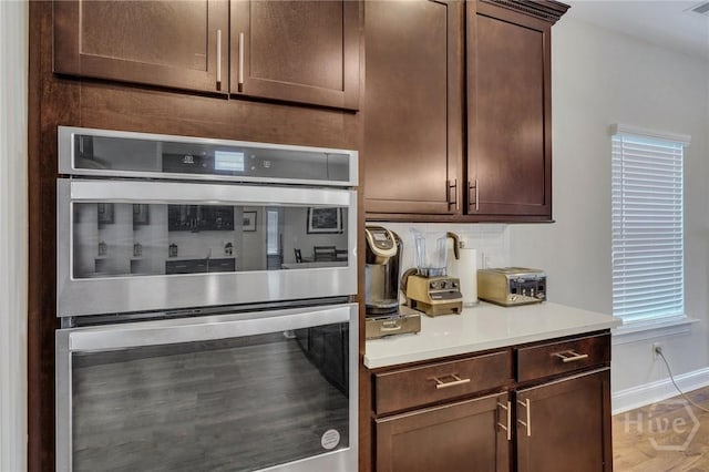 115 Merribee Ln, Pooler, GA 31322 - kitchen featuring double oven, light countertops, dark brown cabinetry, and tasteful backsplash