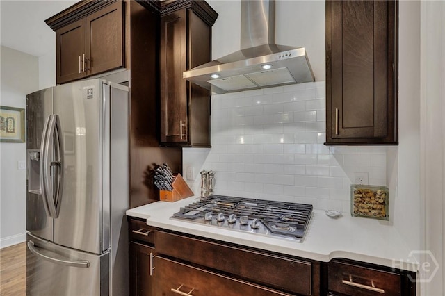 115 Merribee Ln, Pooler, GA 31322 - kitchen with stainless steel appliances, wall chimney range hood, dark brown cabinetry, decorative backsplash, and light countertops