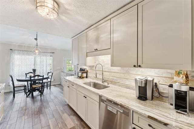 3 Watford Rd, Savannah, GA 31419 - kitchen featuring stainless steel dishwasher, wood finished floors, backsplash, light stone countertops, and a textured ceiling