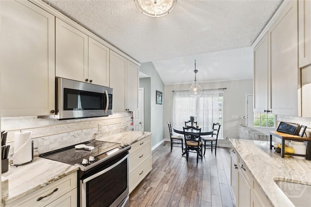3 Watford Rd, Savannah, GA 31419 - kitchen featuring appliances with stainless steel finishes, light wood-style flooring, backsplash, light stone counters, and a textured ceiling