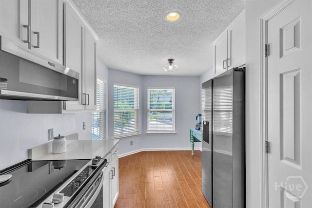 24 Marsh Hen Ct, Richmond Hill, GA 31324 - kitchen featuring stainless steel appliances, a textured ceiling, light wood-type flooring, white cabinetry, and recessed lighting