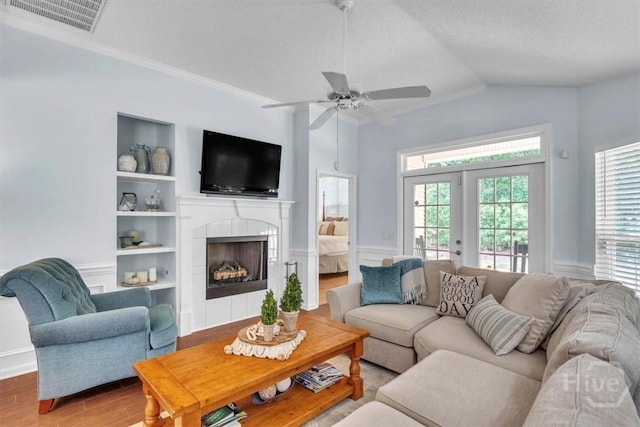 24 Marsh Hen Ct, Richmond Hill, GA 31324 - living area featuring healthy amount of natural light, a fireplace, a wainscoted wall, a ceiling fan, and vaulted ceiling