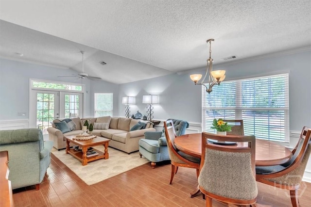 24 Marsh Hen Ct, Richmond Hill, GA 31324 - living area featuring a chandelier, light wood-type flooring, a textured ceiling, a wainscoted wall, and a ceiling fan