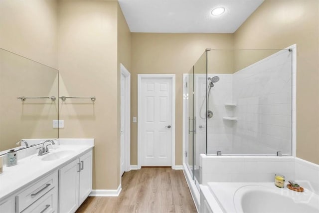 24 Marsh Hen Ct, Richmond Hill, GA 31324 - full bath featuring vanity, a shower stall, a garden tub, and wood finished floors
