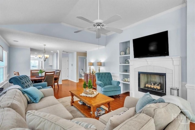 24 Marsh Hen Ct, Richmond Hill, GA 31324 - living room with wood finished floors, ornamental molding, ceiling fan, a tiled fireplace, and a chandelier