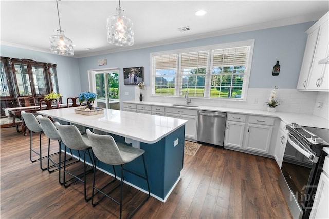 176 Trail Creek Ln, Savannah, GA 31405 - kitchen featuring appliances with stainless steel finishes, a breakfast bar area, light countertops, a center island, and crown molding