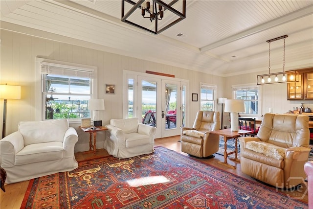 189 E 1st St, Midway, GA 31320 - living area featuring wood finished floors, french doors, beam ceiling, and a chandelier