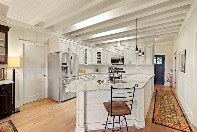 189 E 1st St, Midway, GA 31320 - kitchen with stainless steel appliances, a breakfast bar, glass insert cabinets, light stone countertops, and light wood-style flooring