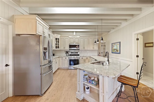 189 E 1st St, Midway, GA 31320 - kitchen with appliances with stainless steel finishes, beamed ceiling, a breakfast bar, light wood-style flooring, and tasteful backsplash