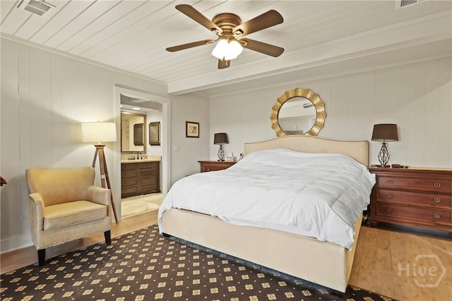 189 E 1st St, Midway, GA 31320 - bedroom featuring wood finished floors, connected bathroom, and a ceiling fan