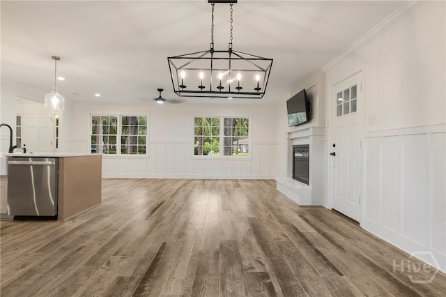 103 Kentshire Ct, Savannah, GA 31410 - unfurnished living room featuring a decorative wall, wood finished floors, ceiling fan, crown molding, and a fireplace