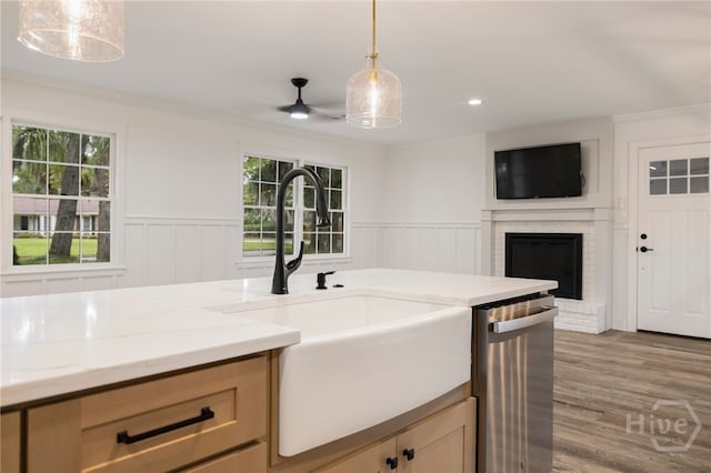 103 Kentshire Ct, Savannah, GA 31410 - kitchen with stainless steel dishwasher, light stone counters, hanging light fixtures, open floor plan, and a brick fireplace