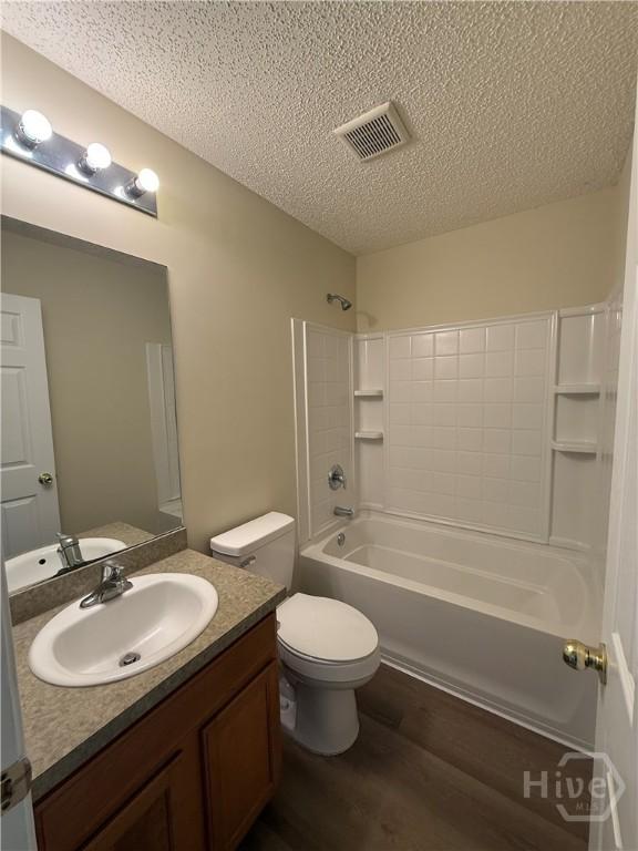 150 Knotty Pine Cir, Springfield, GA 31329 - bathroom with a textured ceiling, wood finished floors, vanity, and washtub / shower combination