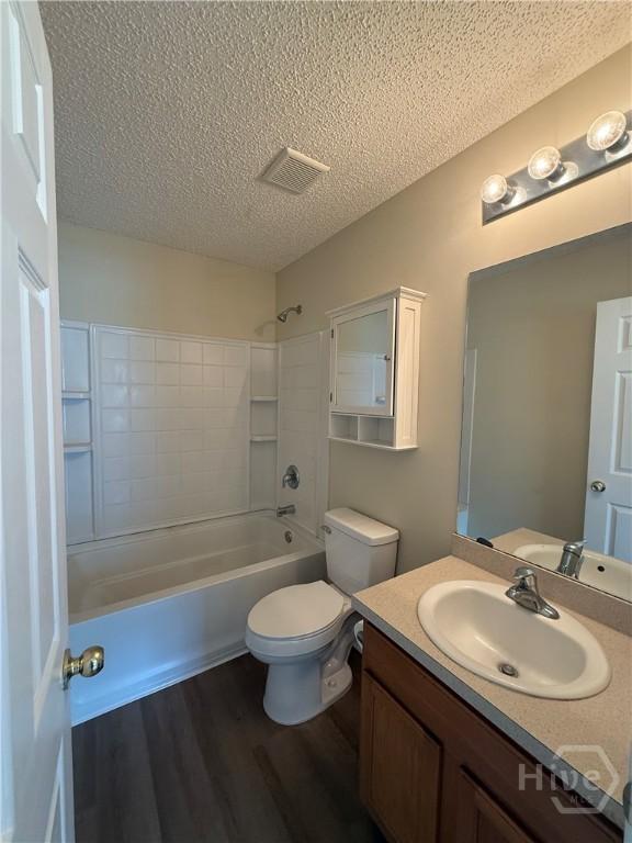150 Knotty Pine Cir, Springfield, GA 31329 - bathroom with a textured ceiling, wood finished floors, vanity, and washtub / shower combination