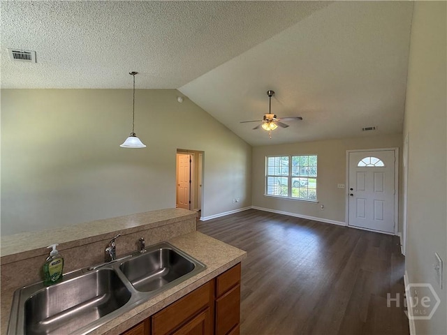 150 Knotty Pine Cir, Springfield, GA 31329 - kitchen featuring brown cabinetry, dark wood-type flooring, a ceiling fan, decorative light fixtures, and light countertops