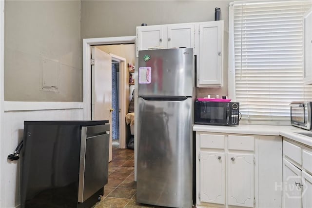 545 E Macon St, Savannah, GA 31401 - kitchen featuring freestanding refrigerator, black microwave, white cabinets, and light countertops