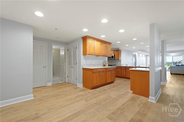 3113 River Dr Unit 10, Savannah, GA 31404 - kitchen with light countertops, light wood-type flooring, stainless steel microwave, open floor plan, and recessed lighting