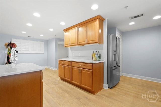 3113 River Dr Unit 10, Savannah, GA 31404 - kitchen featuring stainless steel fridge with ice dispenser, light wood-type flooring, recessed lighting, and brown cabinetry