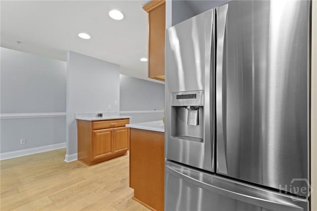 3113 River Dr Unit 10, Savannah, GA 31404 - kitchen with stainless steel fridge with ice dispenser, light countertops, light wood-type flooring, recessed lighting, and brown cabinetry