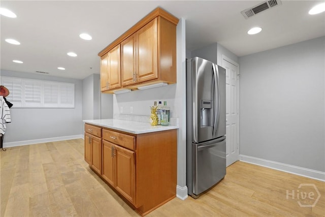 3113 River Dr Unit 10, Savannah, GA 31404 - kitchen with stainless steel refrigerator with ice dispenser, light countertops, light wood finished floors, brown cabinetry, and recessed lighting