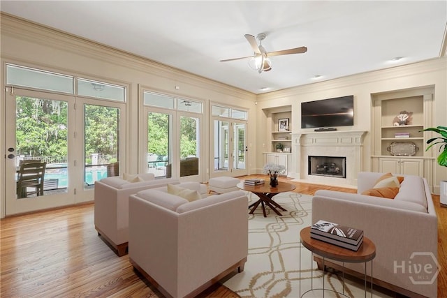 26 Little Comfort Rd, Savannah, GA 31411 - living room with ornamental molding, ceiling fan, built in features, a high end fireplace, and light wood-style floors