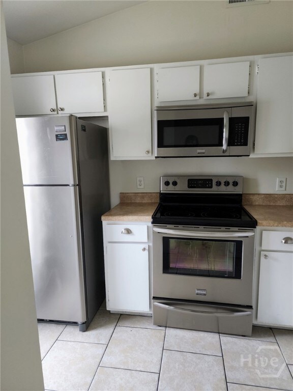 910 Brett Dr Unit 136, Hinesville, GA 31313 - kitchen featuring stainless steel appliances, vaulted ceiling, white cabinets, and light tile patterned flooring